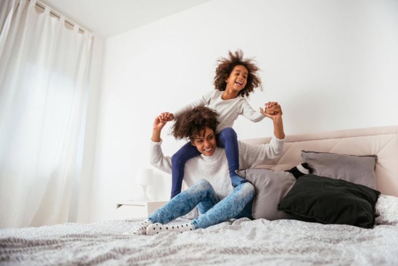 Does an AC Kill Mold? Mom and Daughter on bed.