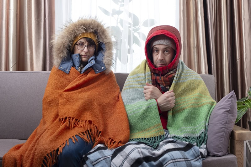 Family freezing in their home's living room from spotty heat.