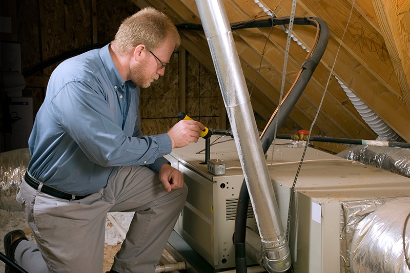 7 Furnace Maintenance Tips - Guy Seasonally Maintenances a Furnace.